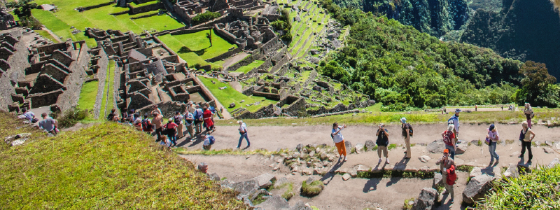 Guide explaining Machu Picchu history to travelers